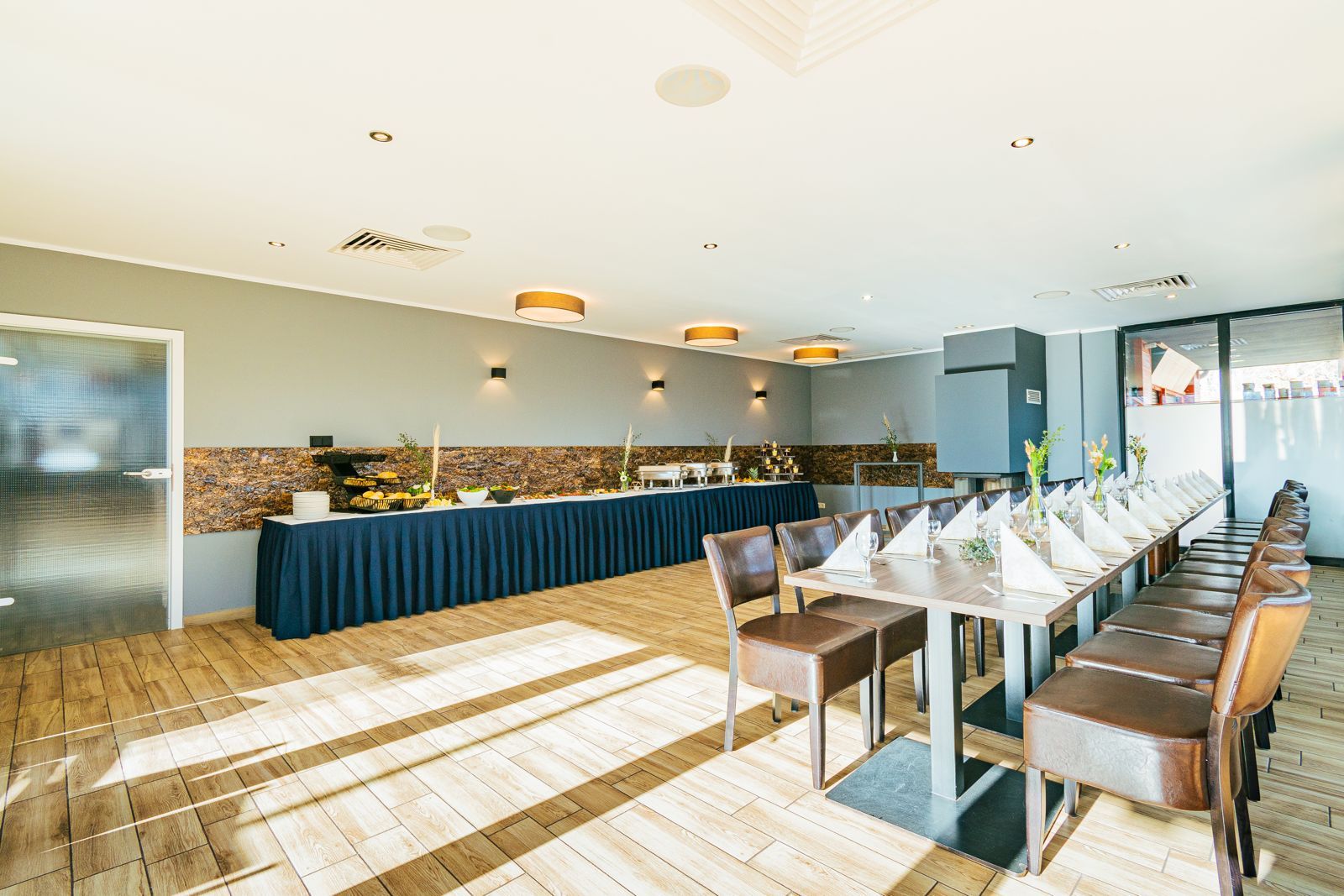 Kaminzimmer mit eingedeckter Hochzeitstafel und Buffet